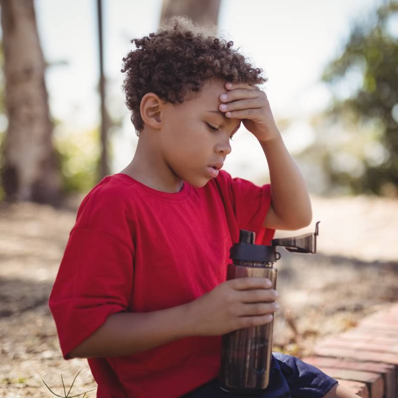 dehydrated-boy-sitting-with-water-bottle