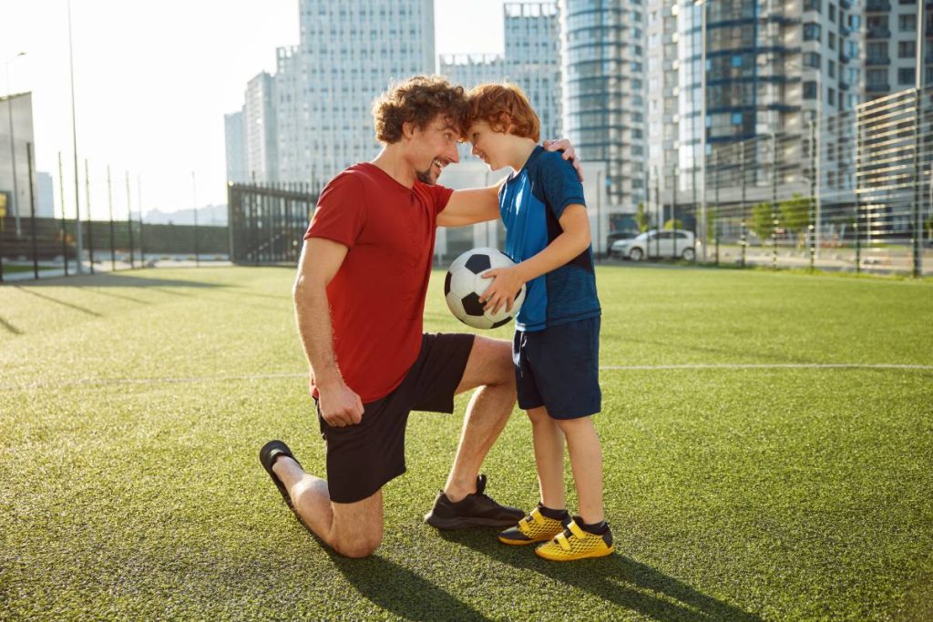 Pere-et-enfant-qui-joue-soccer