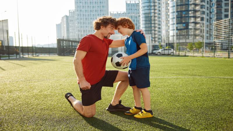 Père et enfant qui joue au soccer