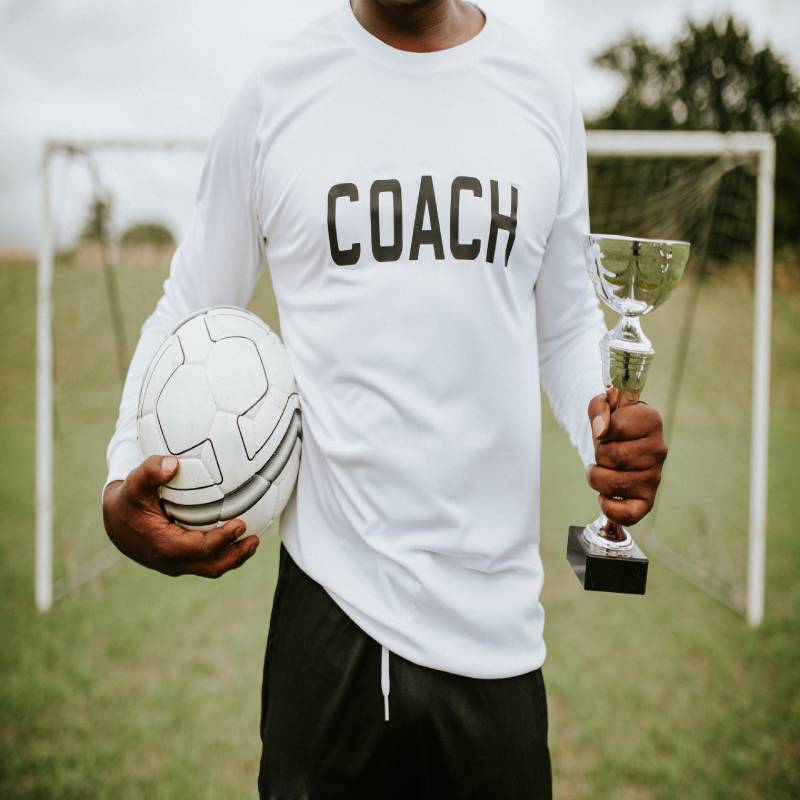 entraîneur avec un ballon de soccer et un trophée