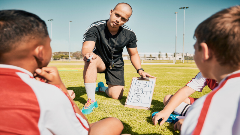 équipe-de-soccer-enfants-et-entraîneur-avec-clipboard